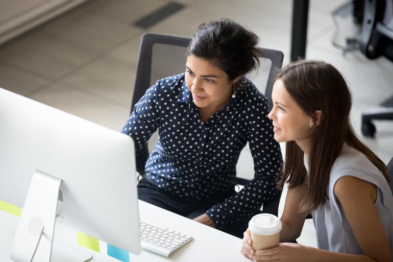 Two people looking at a laptop screen in consultation